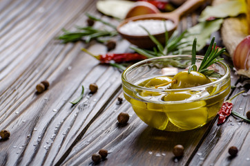 Closeup view of green olives oils and spices on kitchen table. Cooking concept