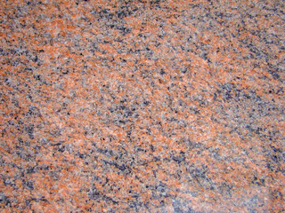 Background red natural granite stone. Black and light blotches and patterns. Texture. Polished...