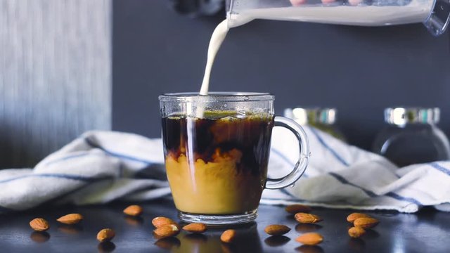 Coffee is poured into a glass mug. Good morning. Delicious drink.