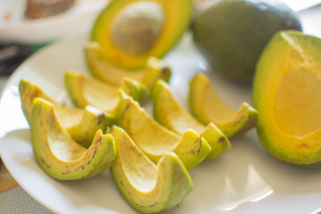 slice of avocado on white dish for healthy fruit. soft focus.