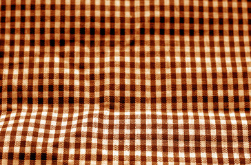 Checked fabric texture in blur effect in orange tone.