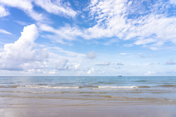 Yellow warm sand and summer sea with blue sky and copy space. Sea view during daytime with blue sky and white clouds. Summer season concept.