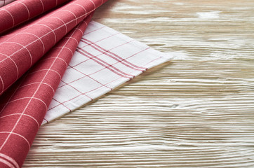 Old light wooden background. Wooden table with red and white kitchen towels