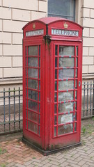 A heavily soiled and neglected red telephone box in Belfast, Northern Ireland