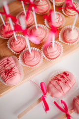 Round, raspberry keypops on a wooden tray