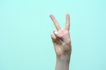 Fototapeta premium female fingers show victory sign on an isolated background. Concept - successful completion of the case