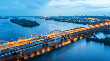 aerial night city view, luminous buildings and bridge. Drone shot.