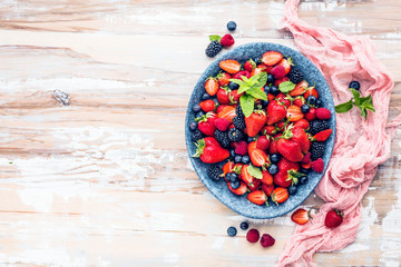 Draufsicht von frischen reifen Erdbeeren, von Blaubeeren und von Brombeeren auf Holztisch mit freiraumraum