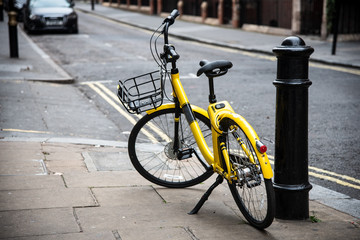 Fototapeta na wymiar Yellow bicycle parked on the road.