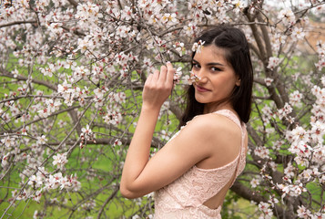 Attractive young beautiful lady, enjoying spring plum blossom flowers