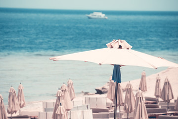 Fototapeta na wymiar Relaxing Beach background with umbrellas and sea 