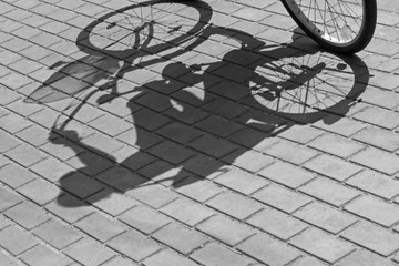Fototapeta na wymiar black and white photo of shadow of woman on bicycle