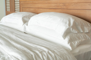 Fototapeta na wymiar White pillow on bed decoration interior of hotel bedroom