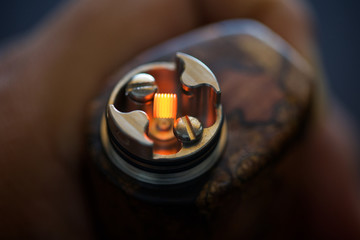 close up, macro shot of test burning the single micro coil in high end rebuildable dripping...