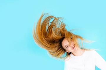 Crazy happy young female doctor in white uniform on bright blue background