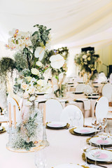 Wedding in a white tent by the lake. Beautiful flowers. luxurious wedding decor in white.