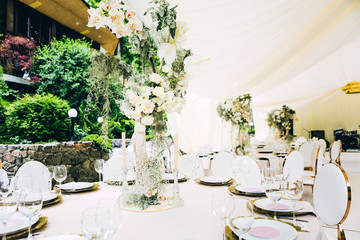 Wedding in a white tent by the lake. Beautiful flowers. luxurious wedding decor in white.