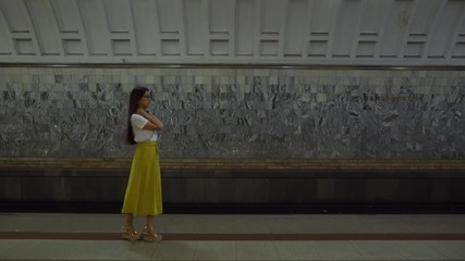 Beautiful girl standing on the platform and waiting for the subway.