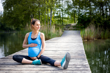 Fototapeta na wymiar Pregnant woman exercising outdoor and resting