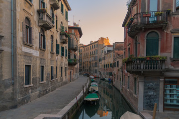 Canal in Venezia, Italy at the sunset with some boats