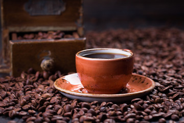 Black coffee in a cup on the background of coffee beans