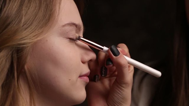 Professional makeup for a young girl on a black background