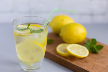 water in a glass with lemon and oregano leaves,a refreshing soft drink to quench your thirst in the heat and maintain tone