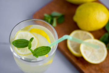 water in a glass with lemon and oregano leaves,a refreshing soft drink to quench your thirst in the heat and maintain tone