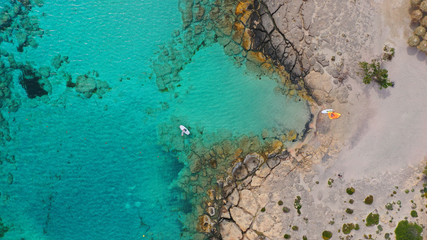 Aerial top view photo of men practising wind surfing in exotic paradise open ocean bay with crystal clear turquoise sea
