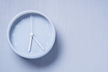 Fototapeta na wymiar Gray alarm clock on gray wooden background.