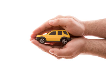 Car protection. Small yellow car covered by hands isolated on white background with clipping path 