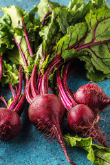Großaufnahme von frischen reifen ungekochten roten Rüben (rote beete )auf blauer Oberfläche