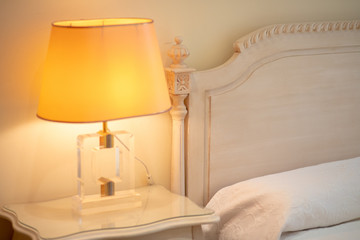 Cozy bedroom interior with book and reading lamp on bedside table