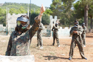 Fototapeta premium Female paintball player in mask with paint