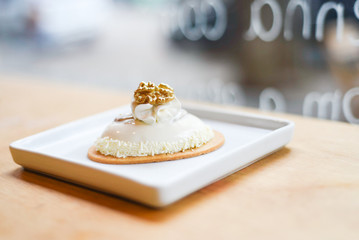 pastry in a white plate on a wooden table with street background 