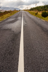 Obraz premium Solid white line down the middle of a rural road in County Donegal, Ireland