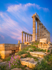 Evening light on stones and columns of temple of Poseidon in Greece