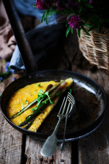 Omelet with asparagus and salmon in iron pan