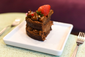 chocolate cake with strawberry on a white plate