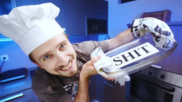 Cook baking shit in glass baking dish 4K. Wide view close-up on person face and dish in focus, smiling into the camera with kitchen in the background out of focus.