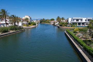 Fototapeta na wymiar Amazing view on marine canals with expensive white houses . Beautiful Resort town landscape with palm trees, little Spanish Venice, Empuriabrava. Rich lifestyle, Summer time.