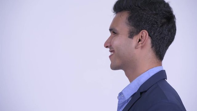 Closeup profile view of happy young Indian businessman smiling