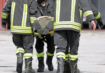 firefighters carrying an injured man on a stretcher