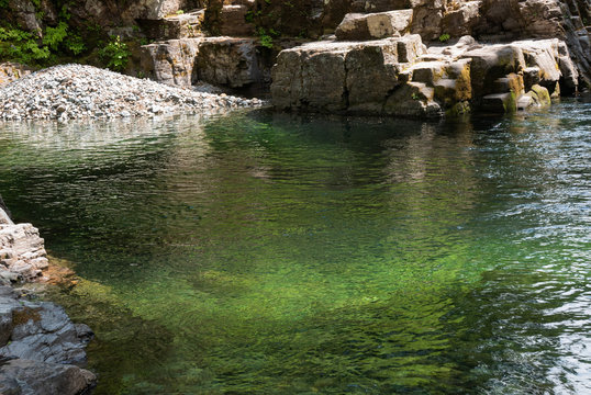 Natural Emerald Green Pool Of Water With Rocks