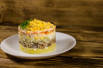 Traditional russian salad Mimosa on wooden table