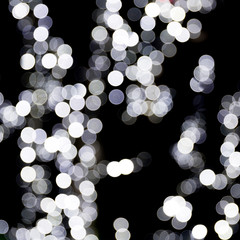 Unfocused abstract white bokeh on black background. defocused and blurred many round light
