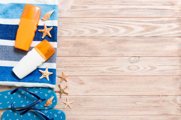 Top view of Beach flat lay accessories. sunscreen bottle with seashells, starfish, towel and...