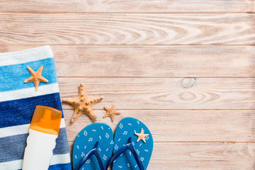 Top view of Beach flat lay accessories. sunscreen bottle with seashells, starfish, towel and...