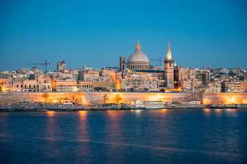 Obraz na płótnie Canvas Panoramic view of Valletta Skyline at beautiful sunset from Sliema with churches of Our Lady of Mount Carmel and St. Paul's Anglican Pro-Cathedral, Valletta, Capital city of Malta