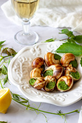 Bourguignonne snail with lemon. Marble background. French cuisine.